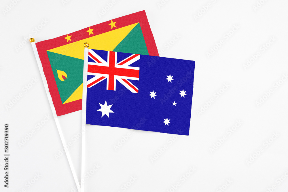 Fototapeta premium Australia and Grenada stick flags on white background. High quality fabric, miniature national flag. Peaceful global concept.White floor for copy space.