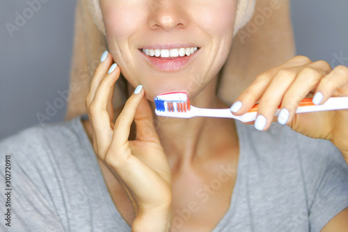 Woman brushing cleaning teeth. Morning routine: girl with toothbrush. Oral hygiene