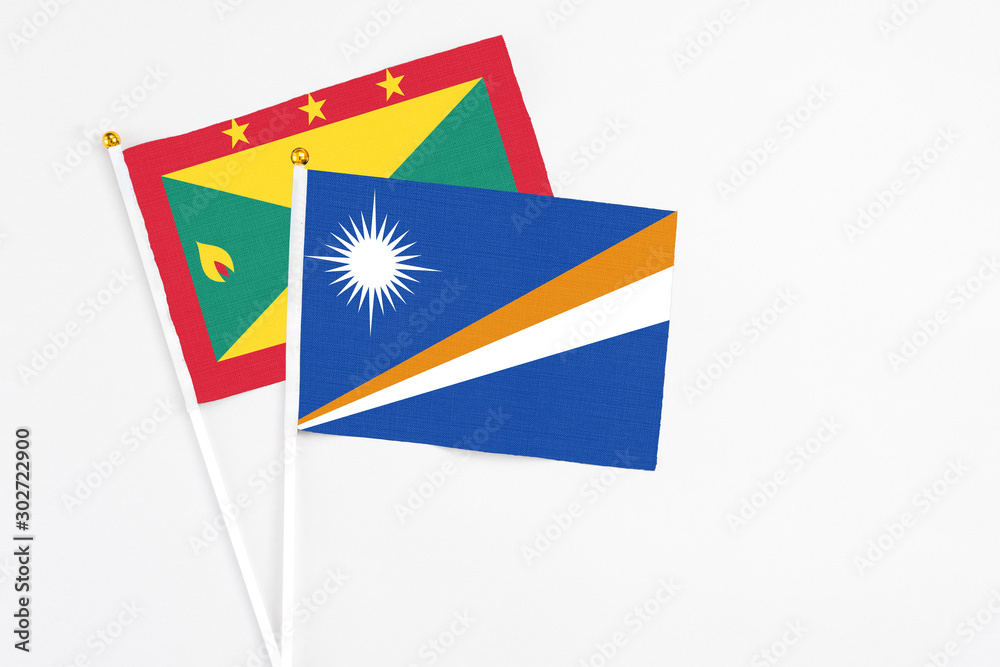 Marshall Islands and Grenada stick flags on white background. High quality fabric, miniature national flag. Peaceful global concept.White floor for copy space. Marshall Islands and Grenada stick flags on white background. High quality fabric, miniature national flag. Peaceful global concept.White floor for copy space.