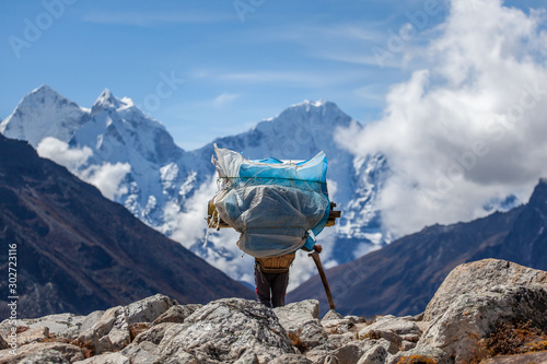 Billede på lærred A porter carrying a heavy load on the everest base camp trek, himalaya, Nepal