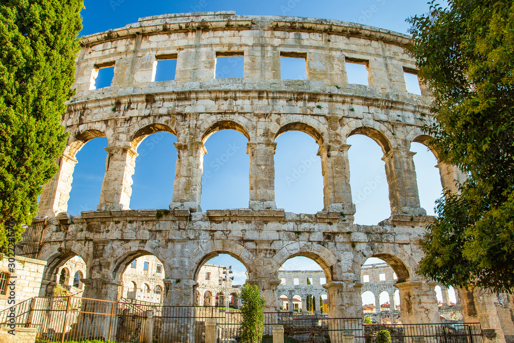 Strong stone arches of monumental ancient Roman arena in Pula, Istria, Croatia.