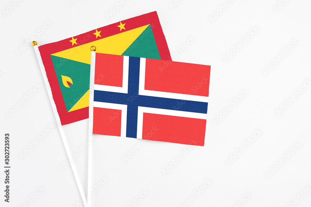 Norway and Grenada stick flags on white background. High quality fabric, miniature national flag. Peaceful global concept.White floor for copy space.