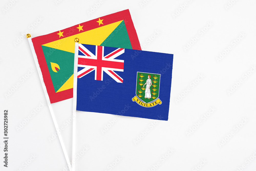 Fototapeta premium British Virgin Islands and Grenada stick flags on white background. High quality fabric, miniature national flag. Peaceful global concept.White floor for copy space.