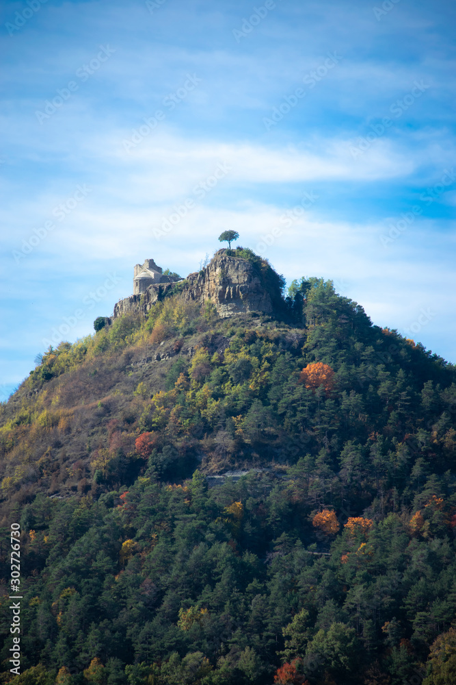 Naklejka premium tree at the top of a hill simbolizing effort