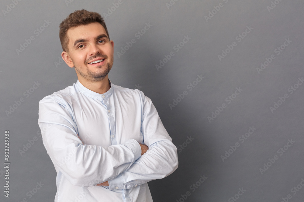 Copy Space for Text or Product. Young man standing studio isolated on grey crossed arms smiling confident Copy Space for Text or Product. Young man standing studio isolated on grey crossed arms smiling confident