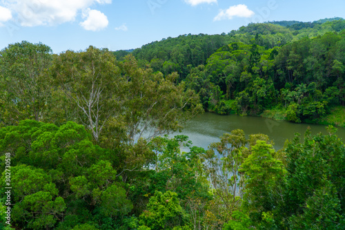 The Australian rainforest in the north of Australia near Cairns with green mountains and blue skies are white clouds