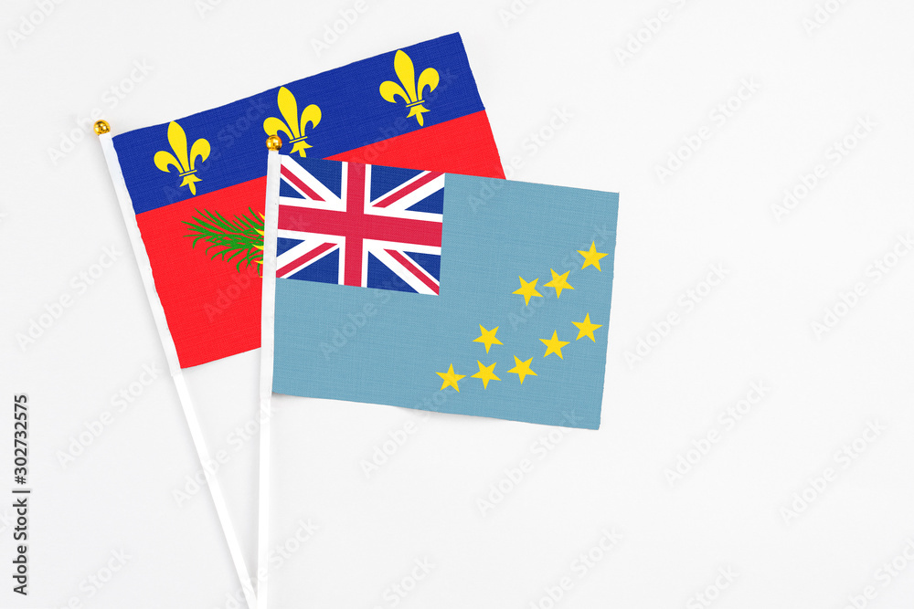 Tuvalu and Guadeloupe stick flags on white background. High quality fabric, miniature national flag. Peaceful global concept.White floor for copy space. Tuvalu and Guadeloupe stick flags on white background. High quality fabric, miniature national flag. Peaceful global concept.White floor for copy space.