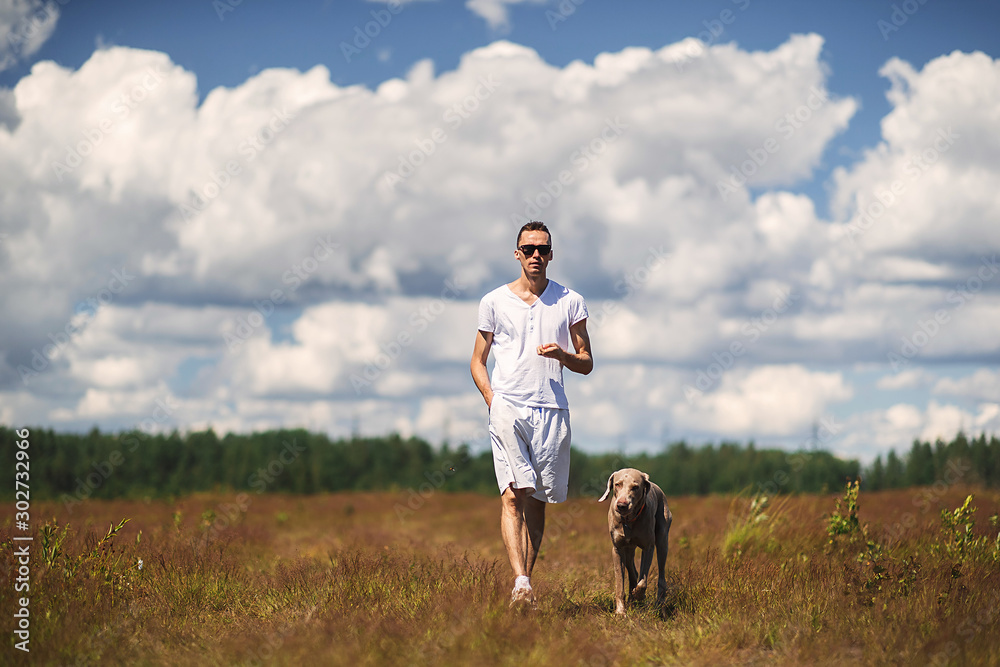 Man walking with dog in rural field Man walking with dog in rural field