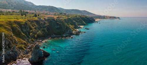 Aerial view of Tropea beach, crystal clear water and rocks that appear on the beach. Calabria, Italy. Swimmers, bathers floating on the water. Coastline of Calabria