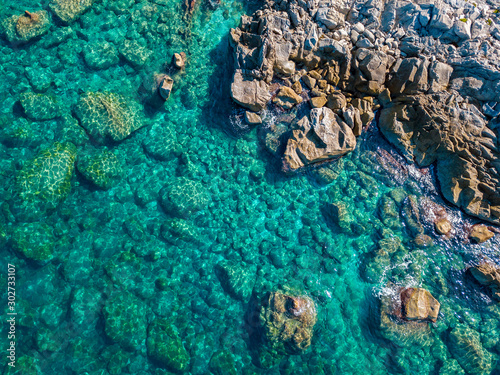 Aerial view of Tropea beach, crystal clear water and rocks that appear on the beach. Calabria, Italy. Swimmers, bathers floating on the water. Coastline of Calabria © Naeblys