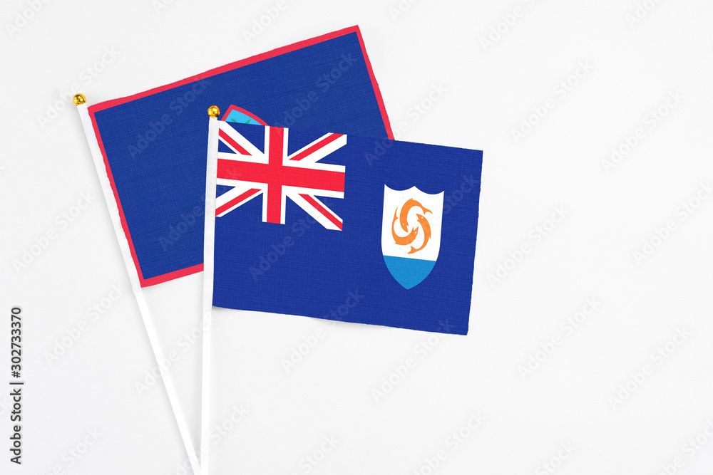 Fototapeta premium Anguilla and Guam stick flags on white background. High quality fabric, miniature national flag. Peaceful global concept.White floor for copy space.