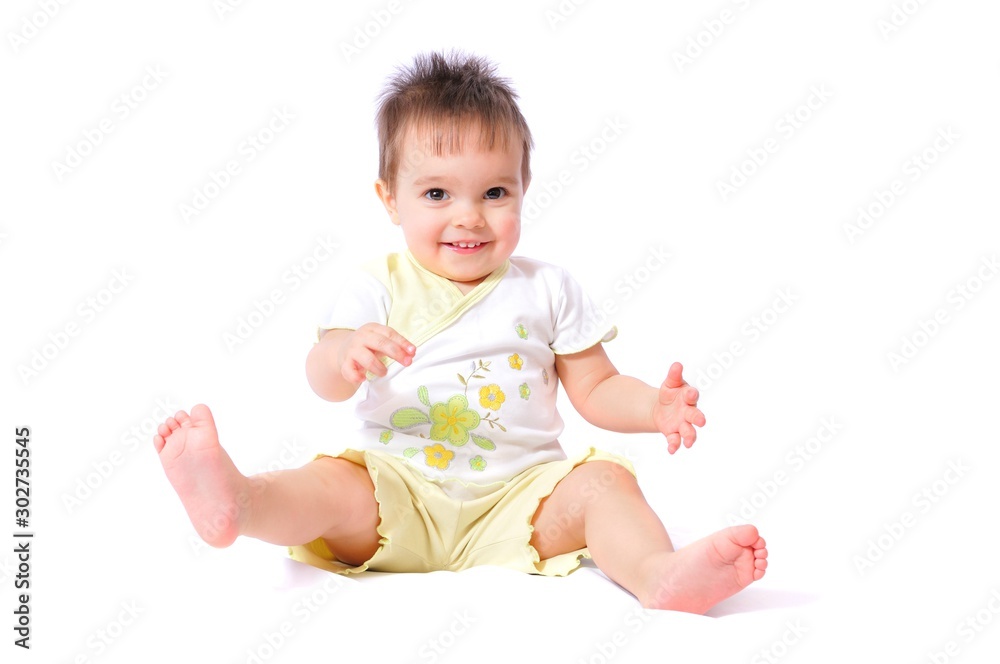 Sitting smiling pretty little one year baby girl in child wear like white t-shirt with flower and yellow shorts fun. Isolated on white background Sitting smiling pretty little one year baby girl in child wear like white t-shirt with flower and yellow shorts fun. Isolated on white background