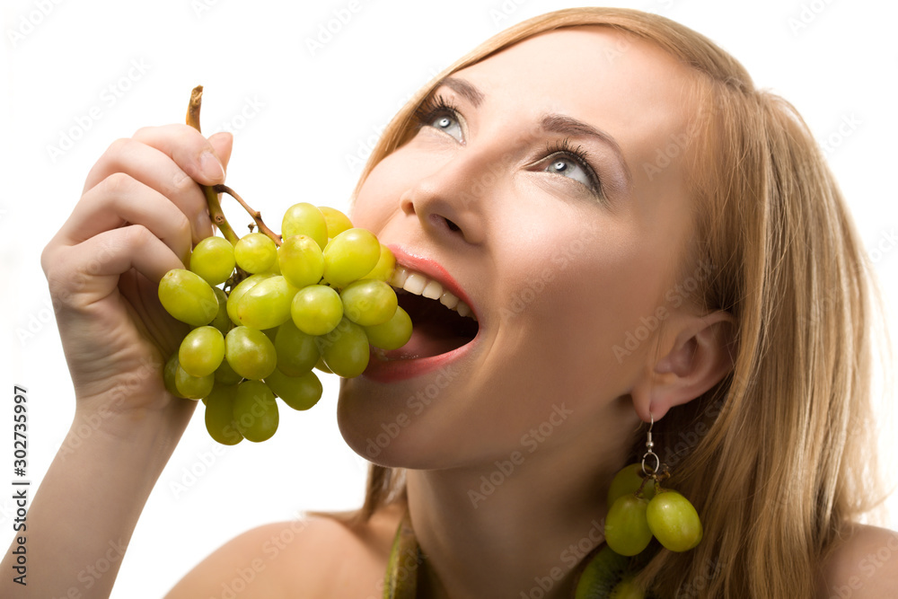 Cheerful european blond woman with short hair posing with green ripe grape in hands. Kiwi slices on body. Health food. Portrait with fruits on white background Cheerful european blond woman with short hair posing with green ripe grape in hands. Kiwi slices on body. Health food. Portrait with fruits on white background