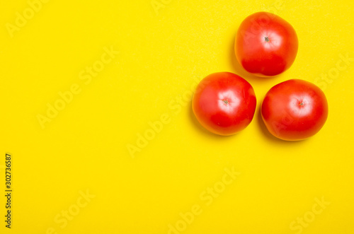 Red tomatoes fresh on yellow background, top view