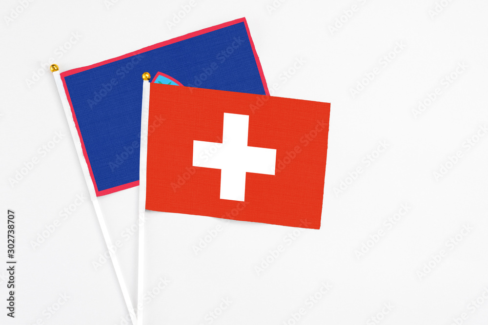 Switzerland and Guam stick flags on white background. High quality fabric, miniature national flag. Peaceful global concept.White floor for copy space.