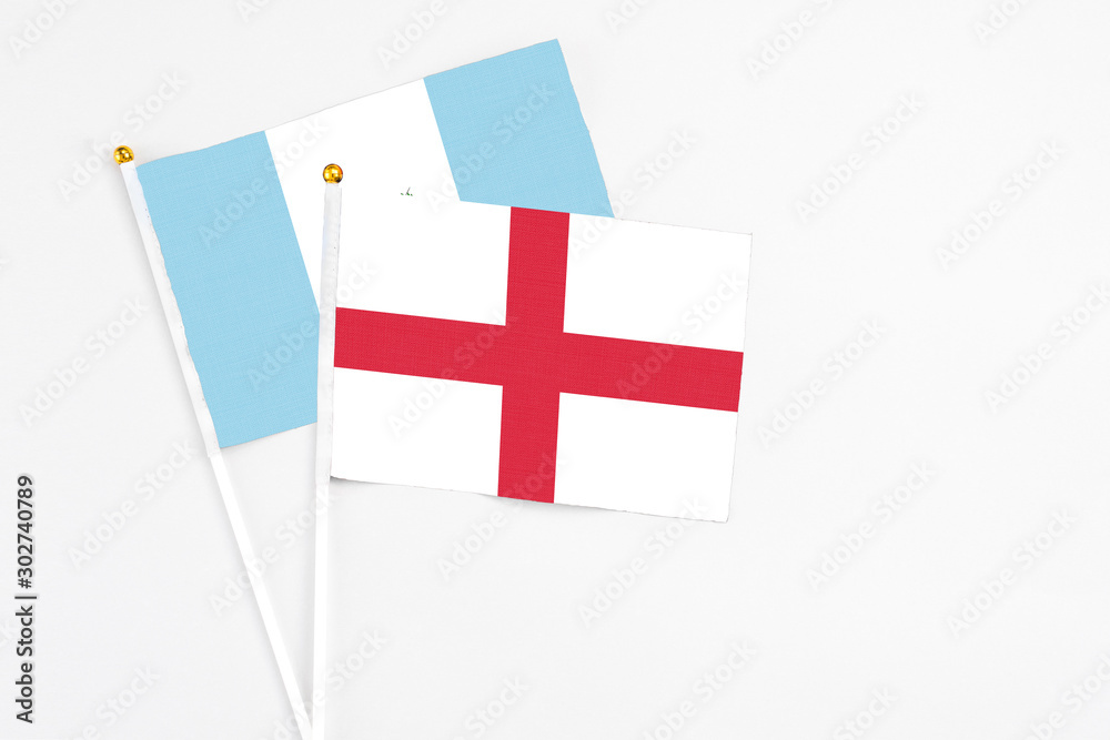 England and Guatemala stick flags on white background. High quality fabric, miniature national flag. Peaceful global concept.White floor for copy space.