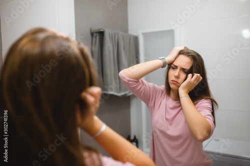 sleepy woman looking in the mirror in bathroom