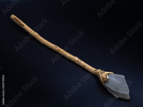 Replicas of the primal stone tool with wooden handles and leather strapping isolated on black background. Primitive stone lance or axe: weapon of the prehistoric peoples. Selected focus.