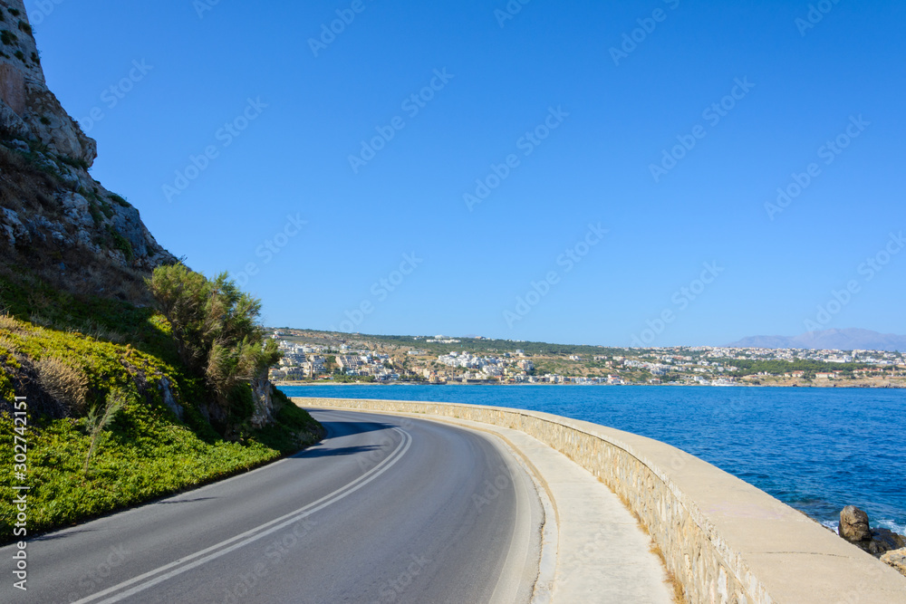 the mountain road along the sea turns towards the city