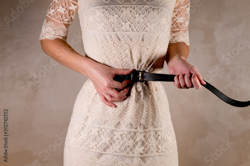 Fotografie the woman tightens the belt very tightly