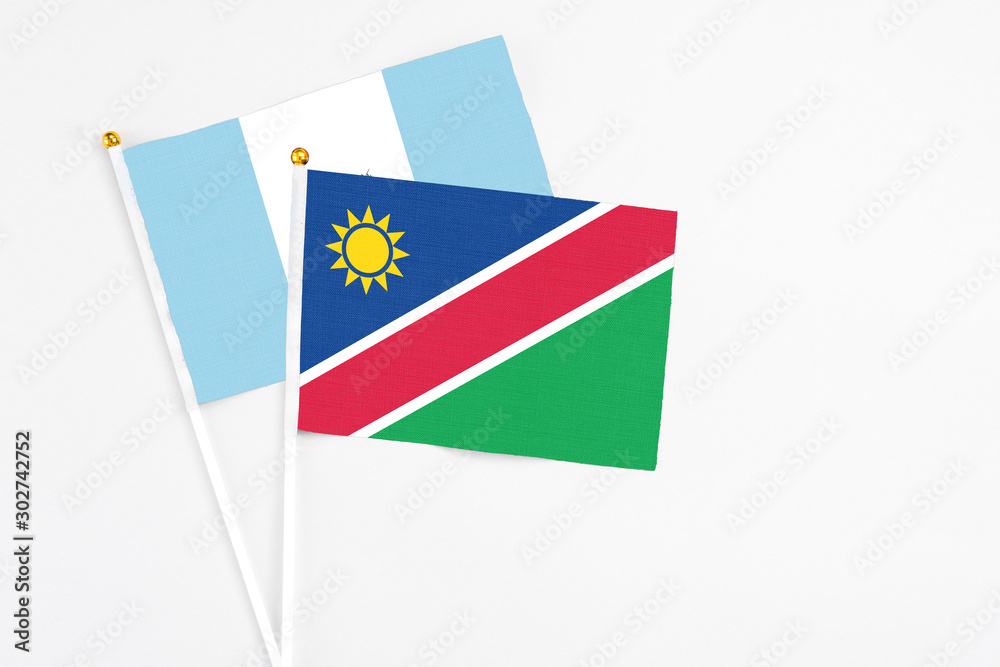 Namibia and Guatemala stick flags on white background. High quality fabric, miniature national flag. Peaceful global concept.White floor for copy space.