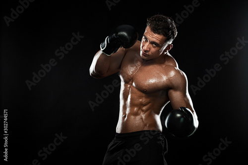 Boxer, man fighting or posing in gloves on black background. Fitness and boxing concept. Individual sports recreation. © Mike Orlov