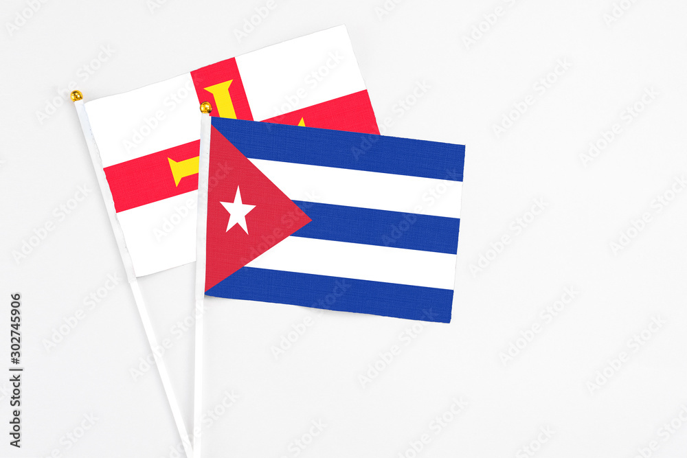 Cuba and Guernsey stick flags on white background. High quality fabric, miniature national flag. Peaceful global concept.White floor for copy space. Cuba and Guernsey stick flags on white background. High quality fabric, miniature national flag. Peaceful global concept.White floor for copy space.