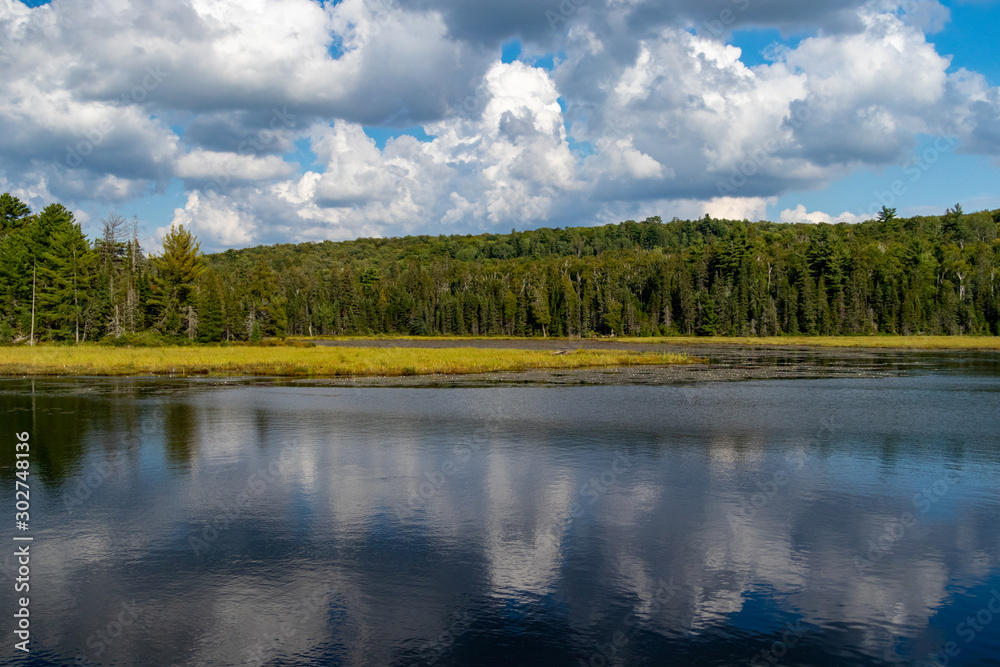 Clouds and blue sky over Canadian lake along Mizzy Lake Trail in Algonquin Provincial Park