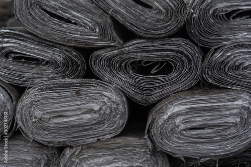 Fotografie twisted sheets of roofing material with rubber coating and protective coating wi