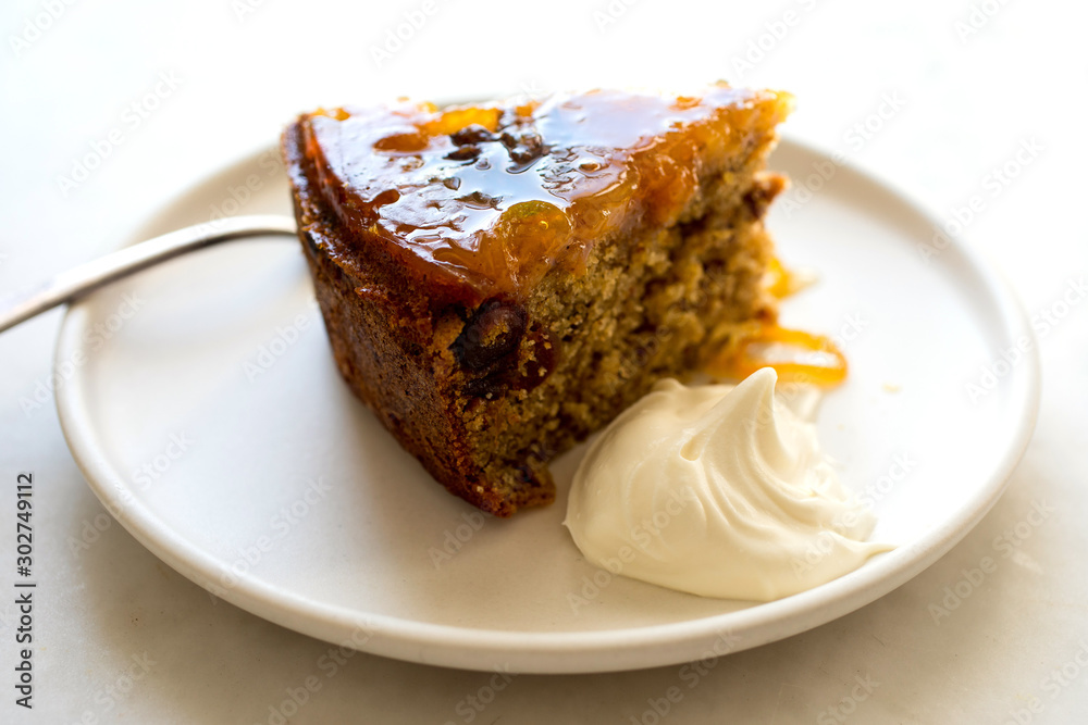 Slice of date upside down cake with cognac mascarpone on plate Slice of date upside down cake with cognac mascarpone on plate