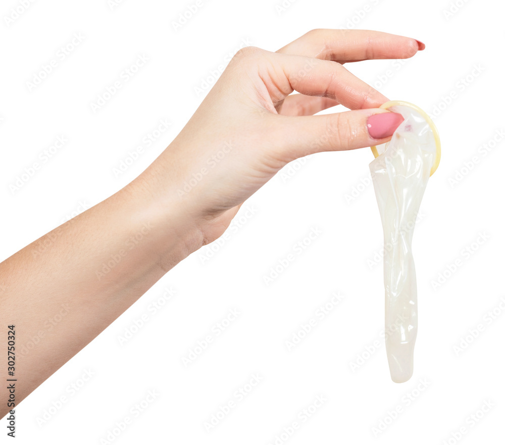 Female hand holding an open condom. Stock Photo
