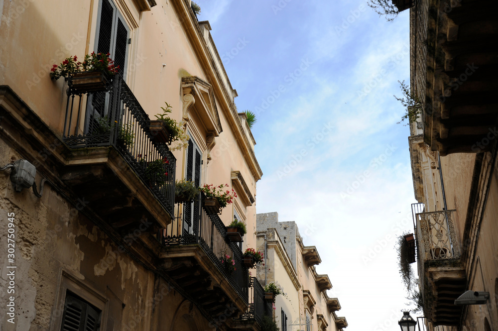 Charming streets of Lecce. Balcony flowery against blue sky. Lecce, Puglia, Italy