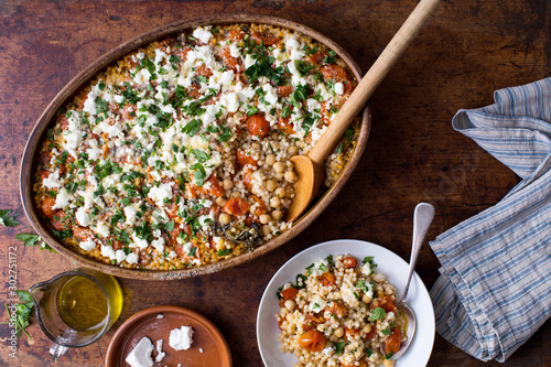 Baked lemony Israeli couscous with chickpeas, tomatoes, and feta