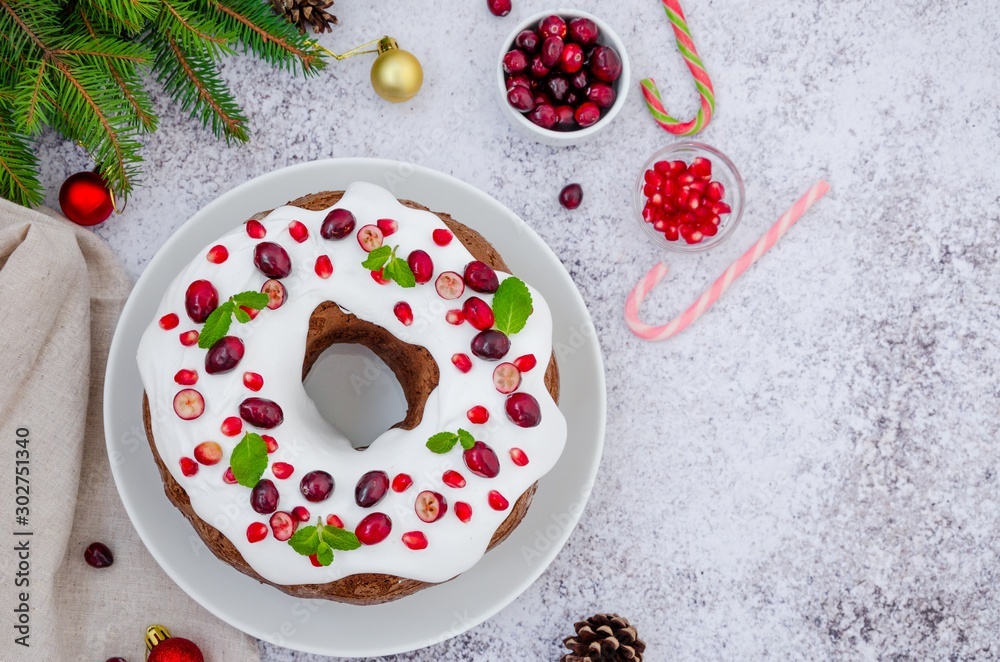 Chocolate cake Christmas wreath with sugar icing, cranberries, pomegranate and mint leaves on top. Festive Dessert for Christmas and New Year. Chocolate cake Christmas wreath with sugar icing, cranberries, pomegranate and mint leaves on top. Festive Dessert for Christmas and New Year.