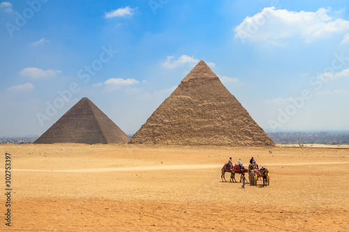 Horse carriage with tourists in front of the Pyramid of Khufu and the Pyramid of Khafre in Egypt