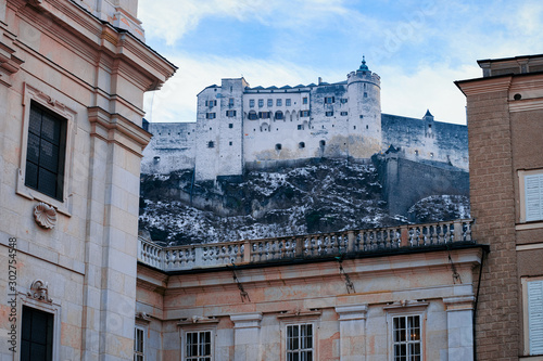 Panorama of Salzburg Hohensalzburg castle in Austria in evening. Landscape and cityscape of Mozart city in Europe at winter. View of old fortress in Austrian town of Salzburgerland. Sky with clouds