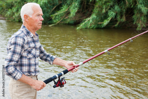 Mature man angling at riverside