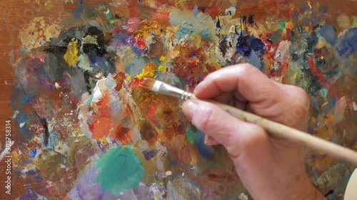 mano mezclando colores en paleta de pintor photo