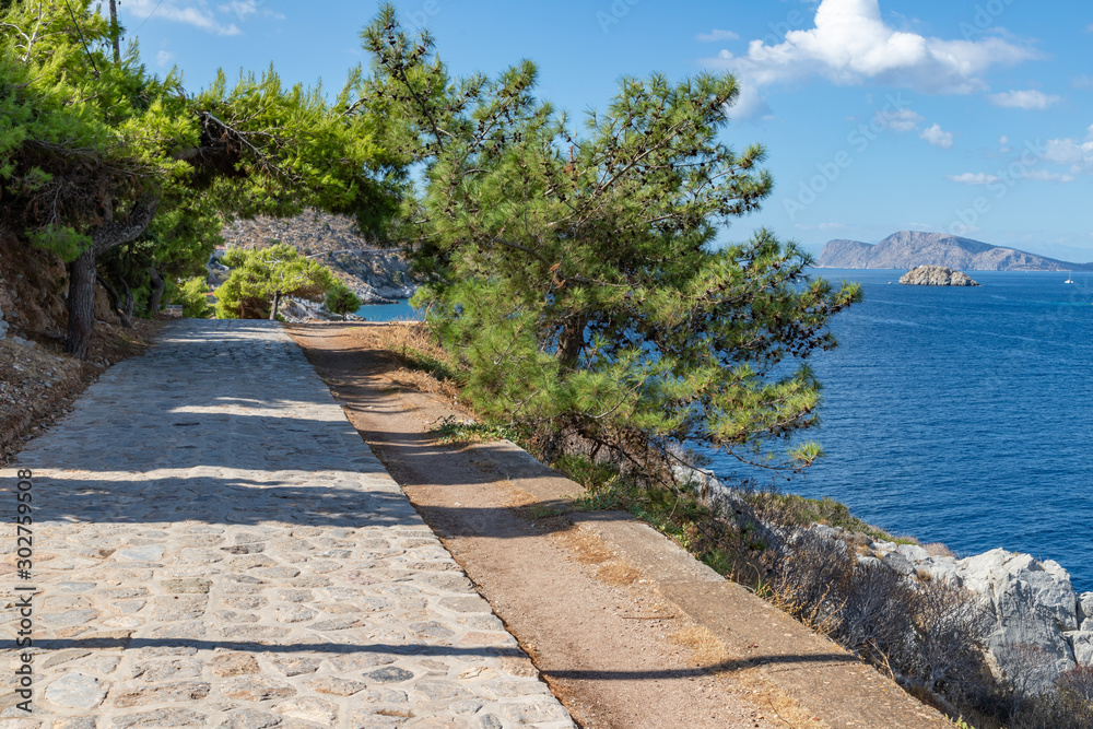 Walking path with vegetation and ocean in background in Hydra Island