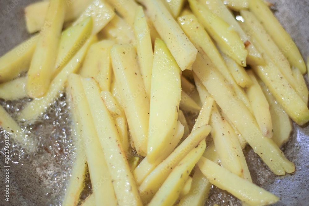 Potatoes are fried in oil. Sliced potatoes in a pan. Potatoes are fried in oil. Sliced potatoes in a pan.