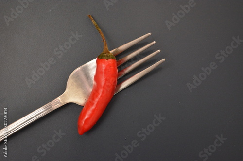 peperoncino rosso piccante ingrediente per cucinare su tavolo con forchetta e coltello di metallo