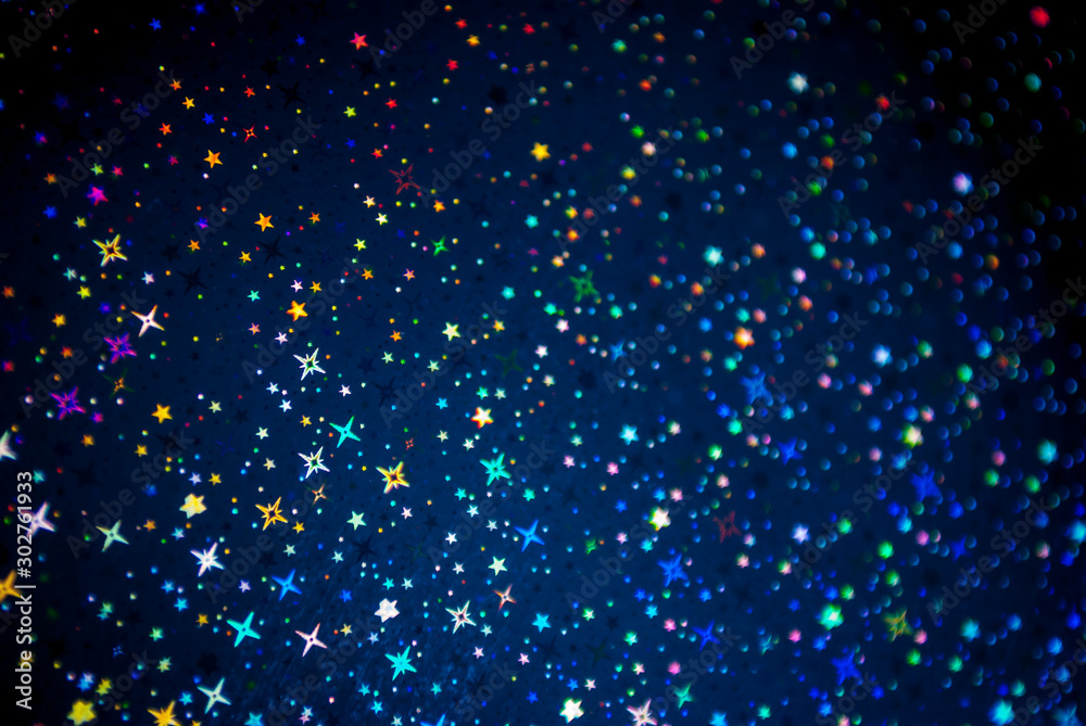 Festive sparkling background in dark dark blue with glowing stars and colorful bokeh lights