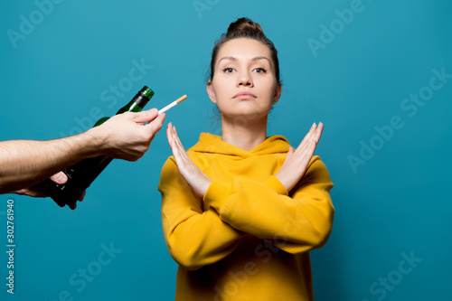 Cuadro en lienzo girl in a yellow sweatshirt refuses alcohol and cigarettes