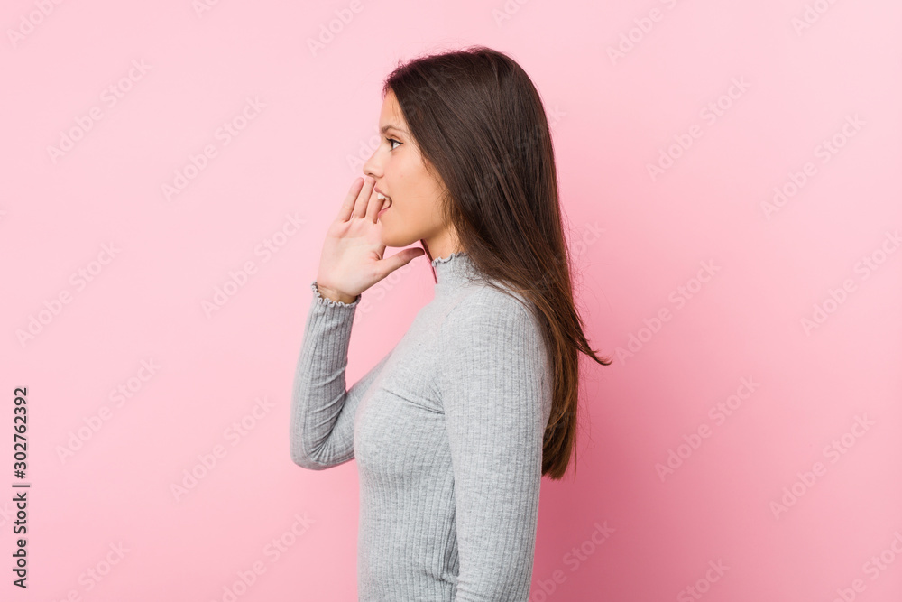 Young cute woman shouting and holding palm near opened mouth. Young cute woman shouting and holding palm near opened mouth.