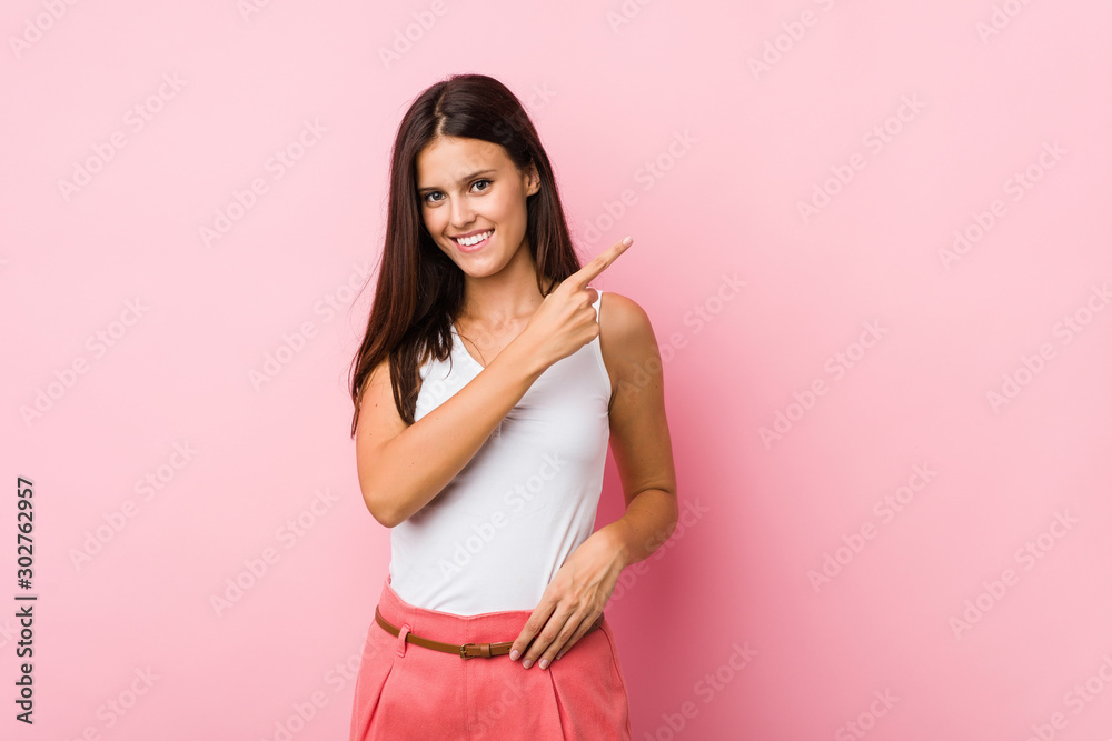 Young cute woman smiling and pointing aside, showing something at blank space. Young cute woman smiling and pointing aside, showing something at blank space.