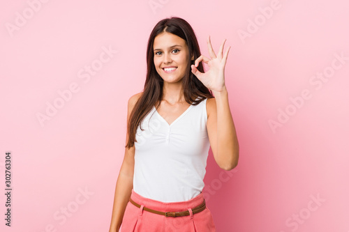 Young cute woman cheerful and confident showing ok gesture.