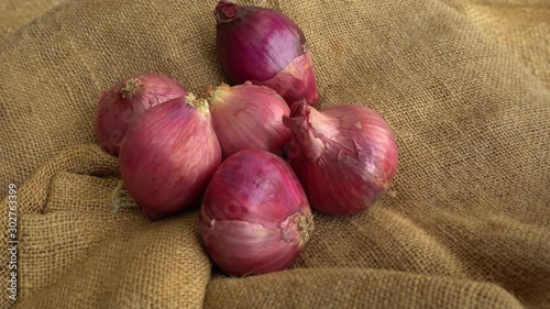 Red purplish Onions rotating on a jute mat 