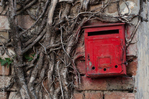 Red old mailbox on the wall. Letter boxes.