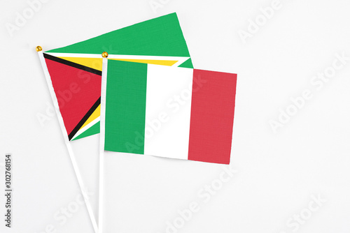 Italy and Guyana stick flags on white background. High quality fabric, miniature national flag. Peaceful global concept.White floor for copy space.