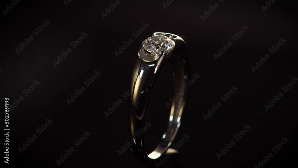 Macro view of engagement ring with diamond on black background. Luxury jewelry Macro view of engagement ring with diamond on black background. Luxury jewelry